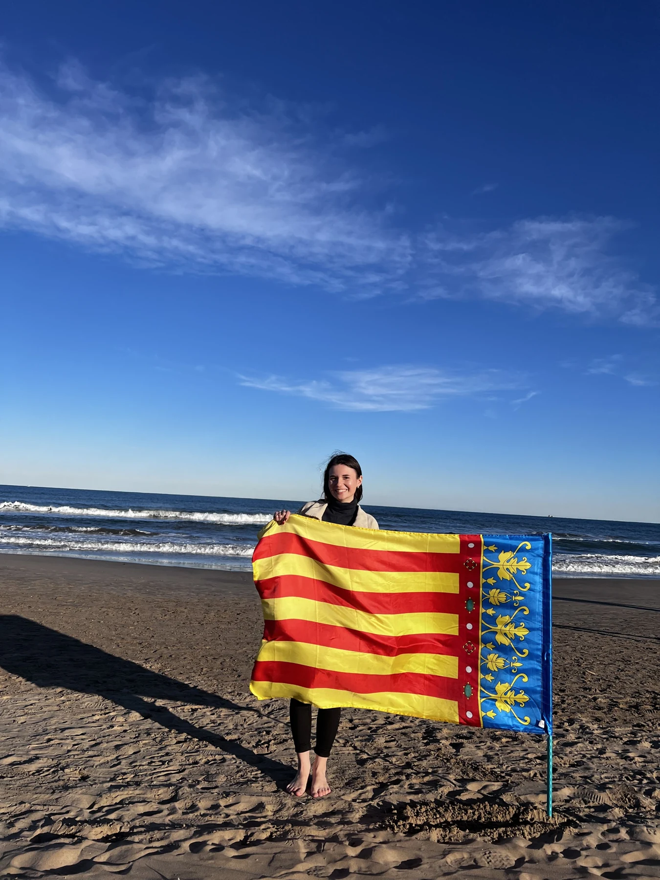 Klaudia na plaży w Walencji z flagą Wspólnoty Walenckiej